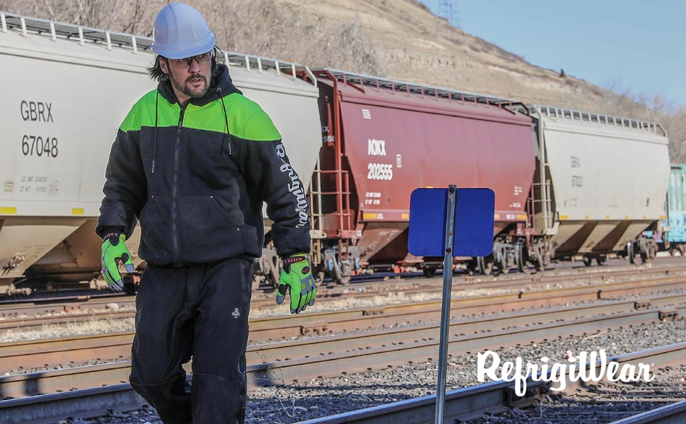 Man wearing Freezer Edge Hooded Sweatshirt working by a train.