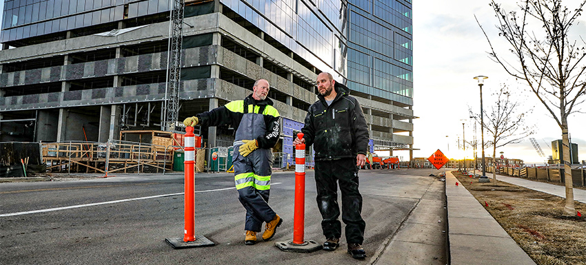 Two construction workers take a break onsite in cold conditions.