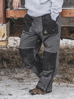 ChillShield Pants: Man wearing insulated workwear pants leaning on work truck in snow. RefrigiWear ChillShield pants.