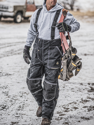 Ergoforce: Man with toolbelt on worksite wearing insulated bib overalls as workwear. RefrigiWear Waterproof ErgoForce Bib Overalls