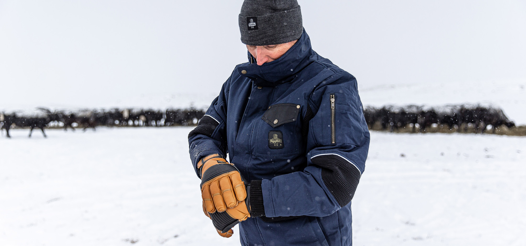 Man in the snow wearing RefrigiWear 54 Gold jacket and gloves