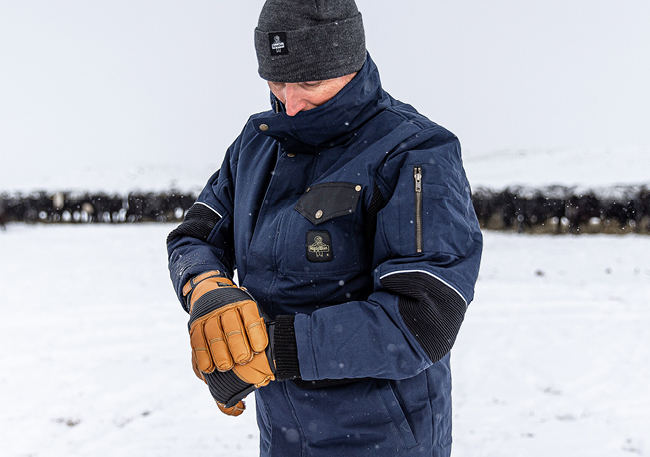 Man in the snow wearing RefrigiWear 54 Gold jacket and gloves